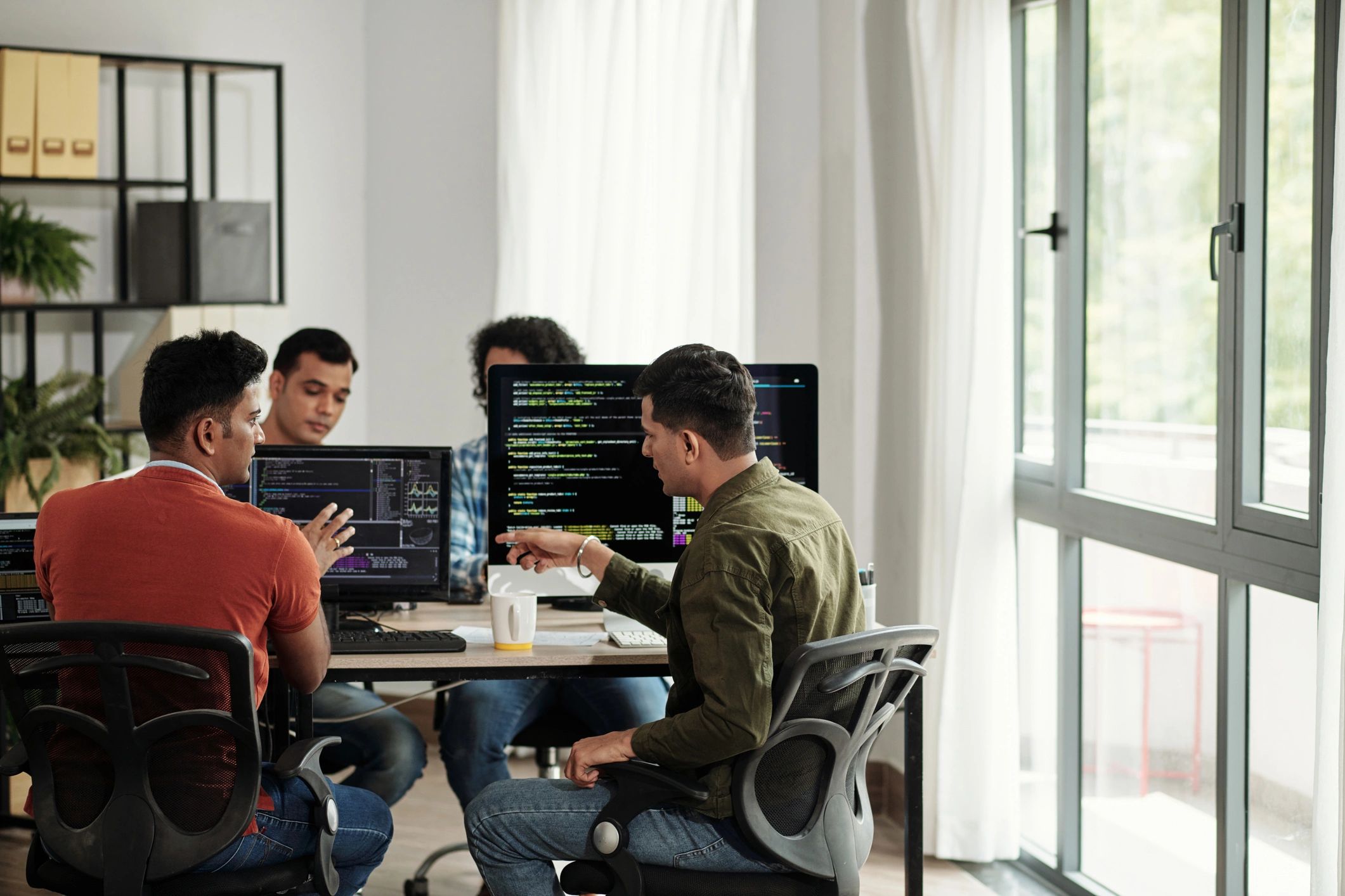 Software engineers collaborating on code review and delivery planning