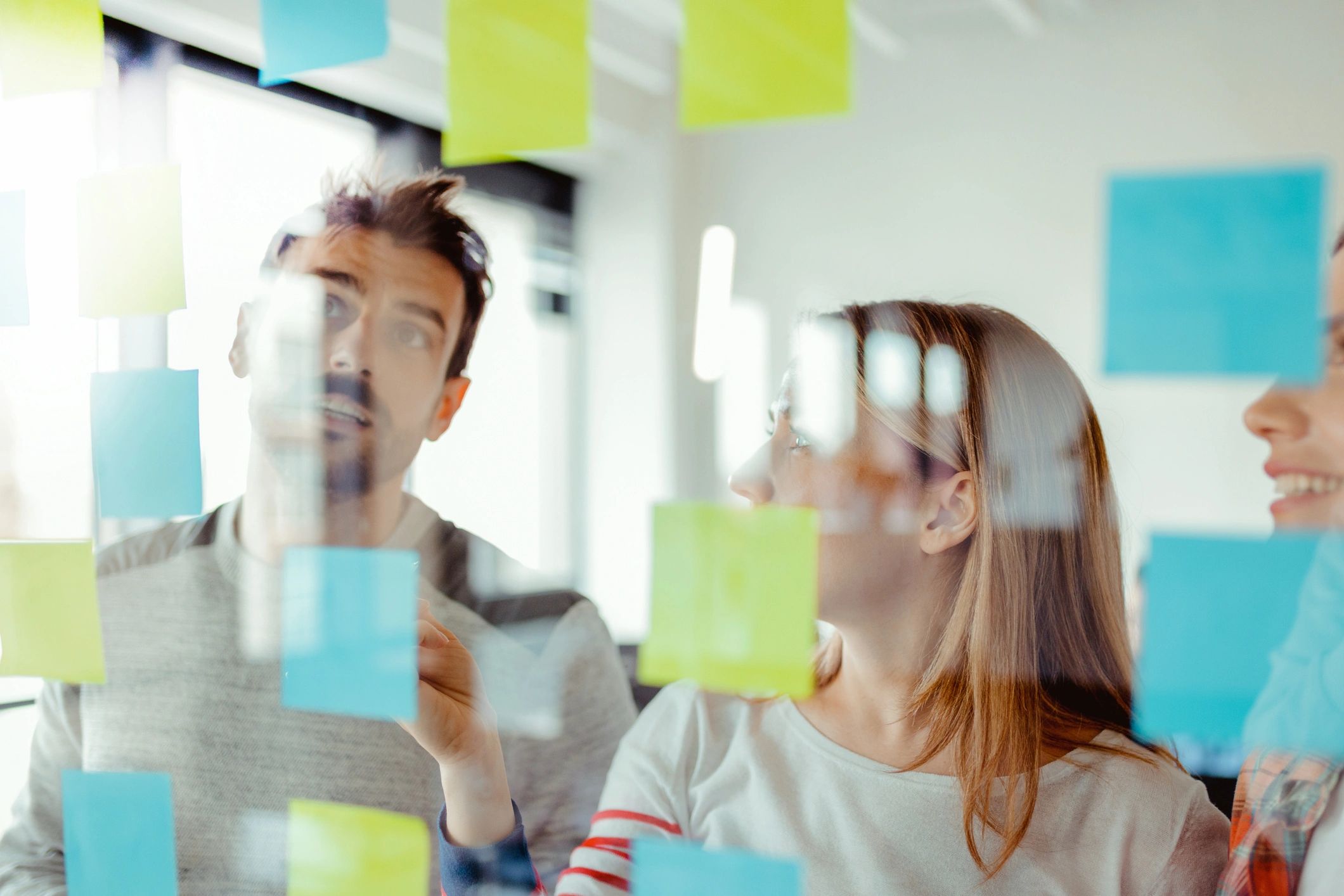 Team planning a project with notes on a glass wall